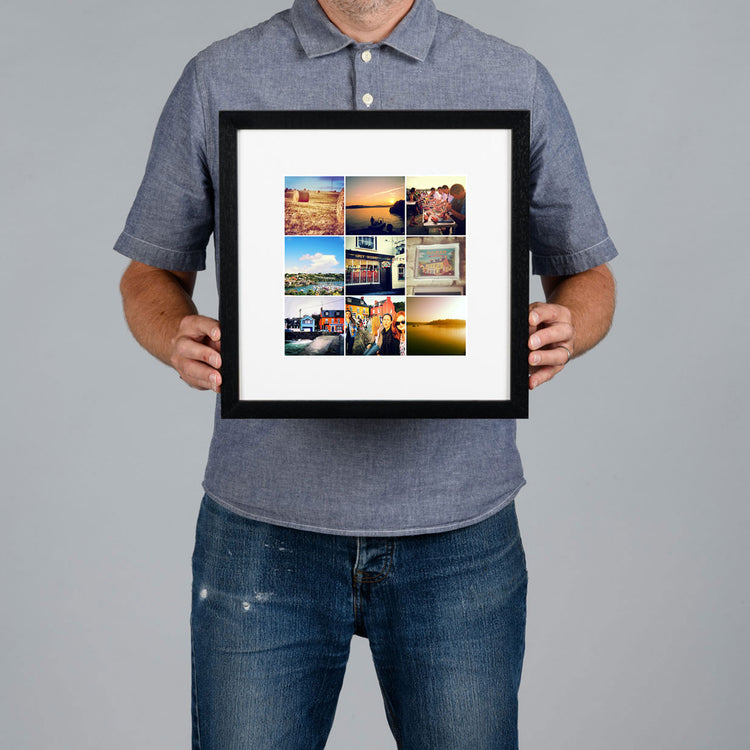 A man holds a black square frame containing a photo grid collage of nine small travel photographs against a plain gray background. The print is 20x20cm and the frame is 34x34cm. 