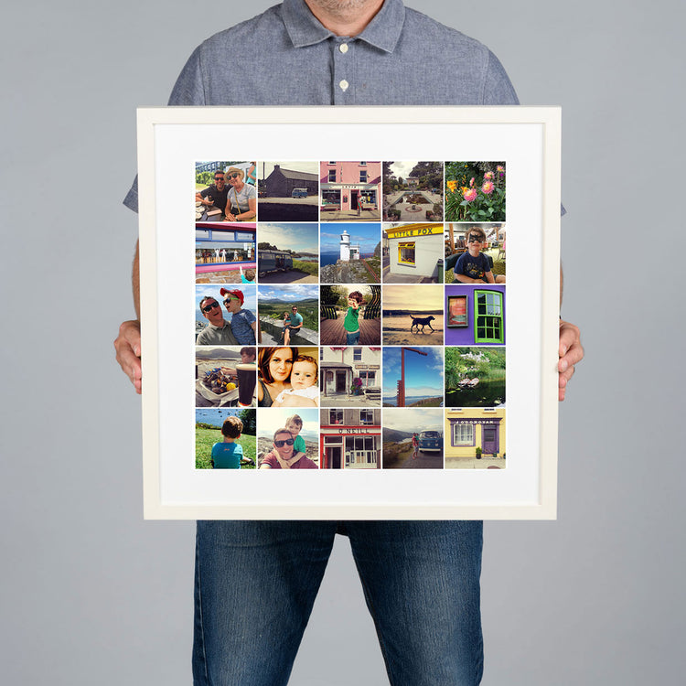 A man holds up a large White framed custom photo grid collage print with a white mat. The collage contains multiple small travel and family photographs. The print is 40x40cm and the frame is 54x54cm. 